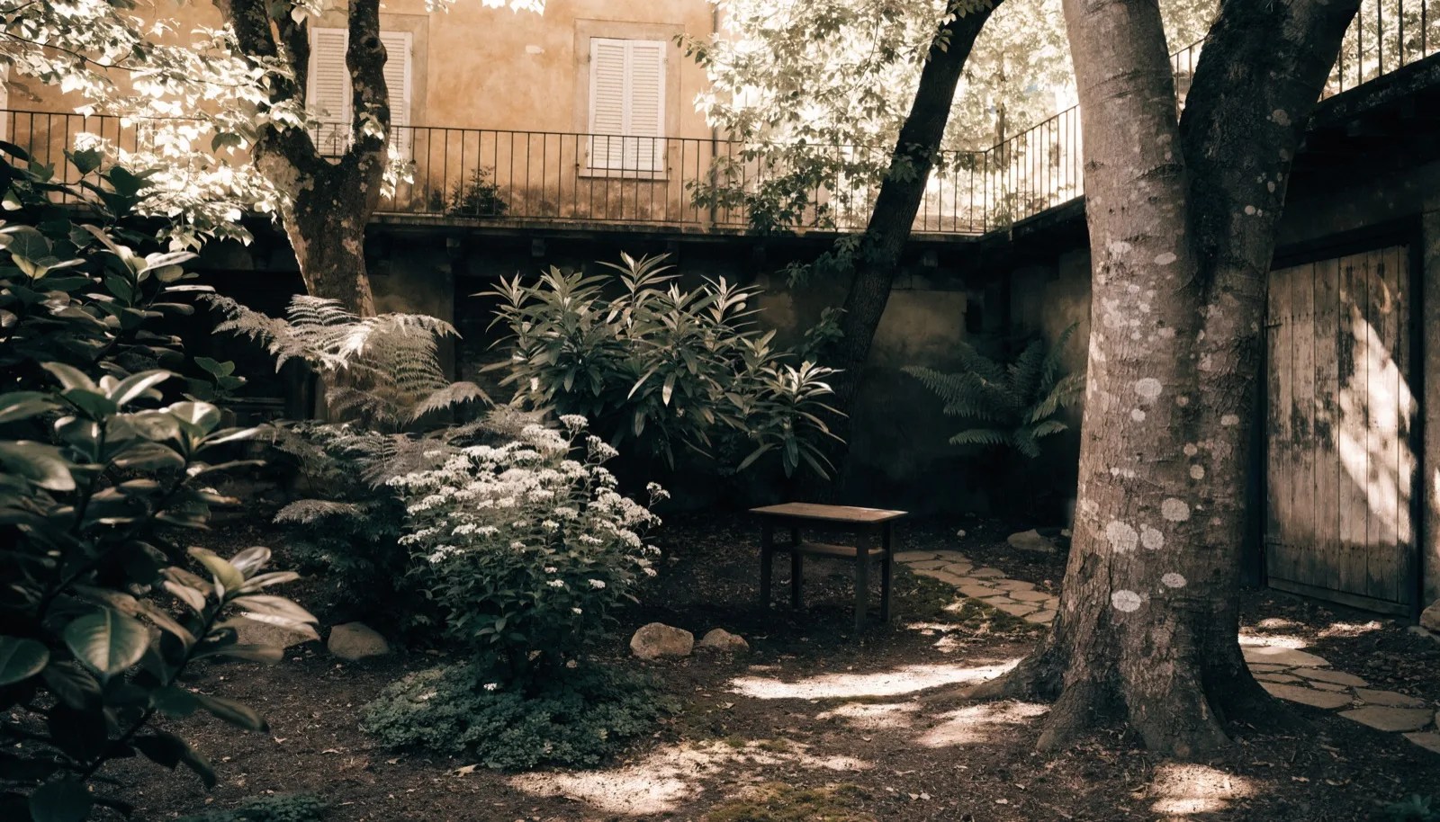 Cortile residenziale con piante a Brescia, luce filtrata tra gli alberi