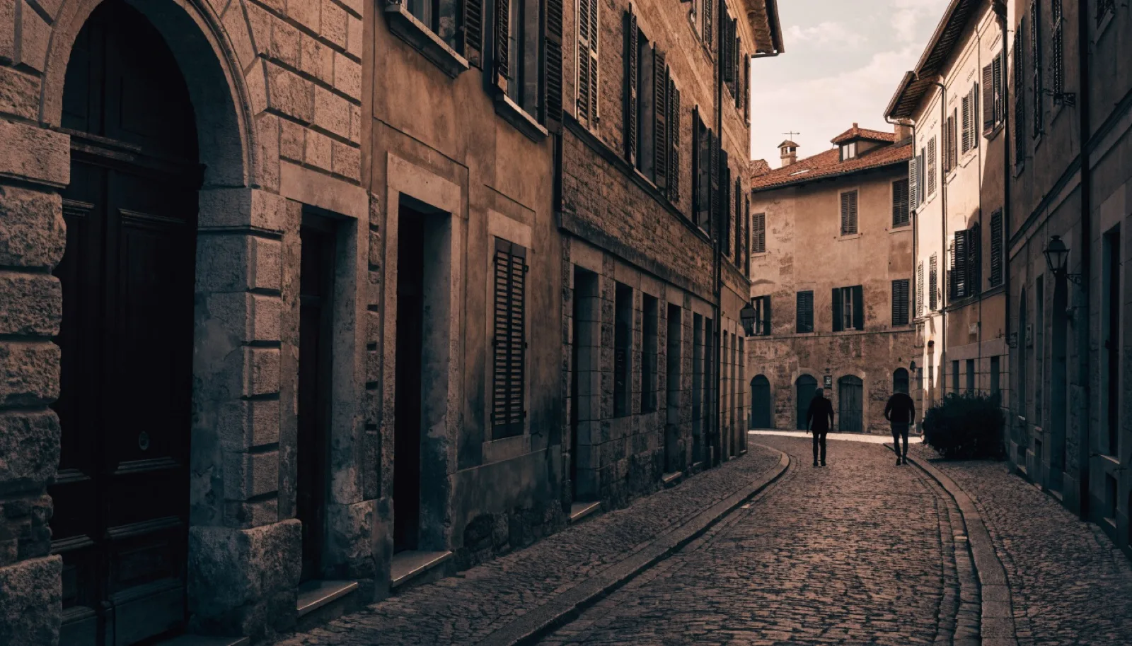 Vicolo acciottolato di Città Alta a Bergamo con edifici in pietra, luce calda al tramonto